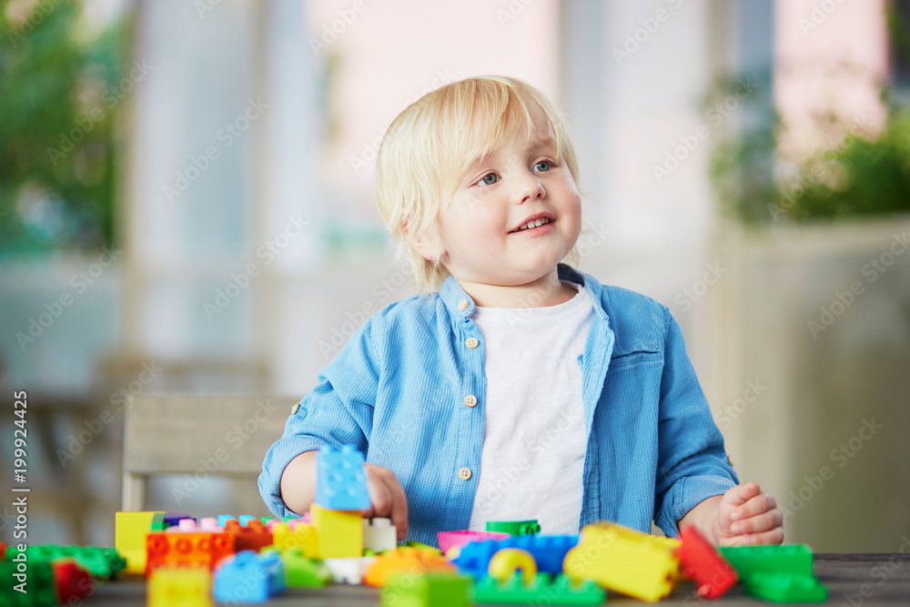 Little boy playing with colorful plastic construction blocks Little boy playing with colorful plastic construction blocks