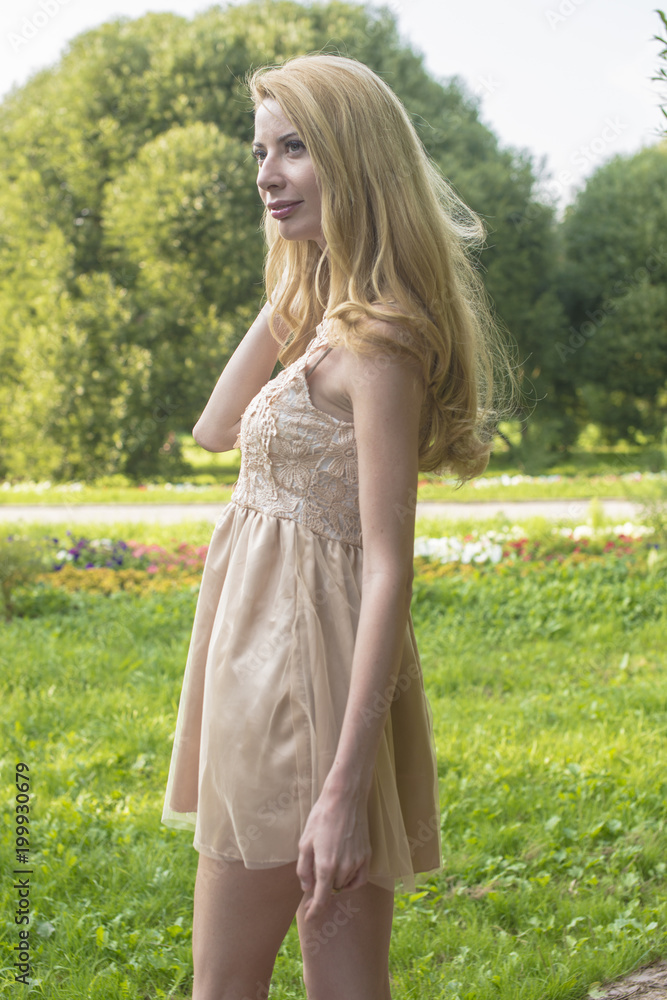Young beautiful blonde woman in a beautiful dress in a summer park
Young beautiful blonde woman in a beautiful dress in a summer park
