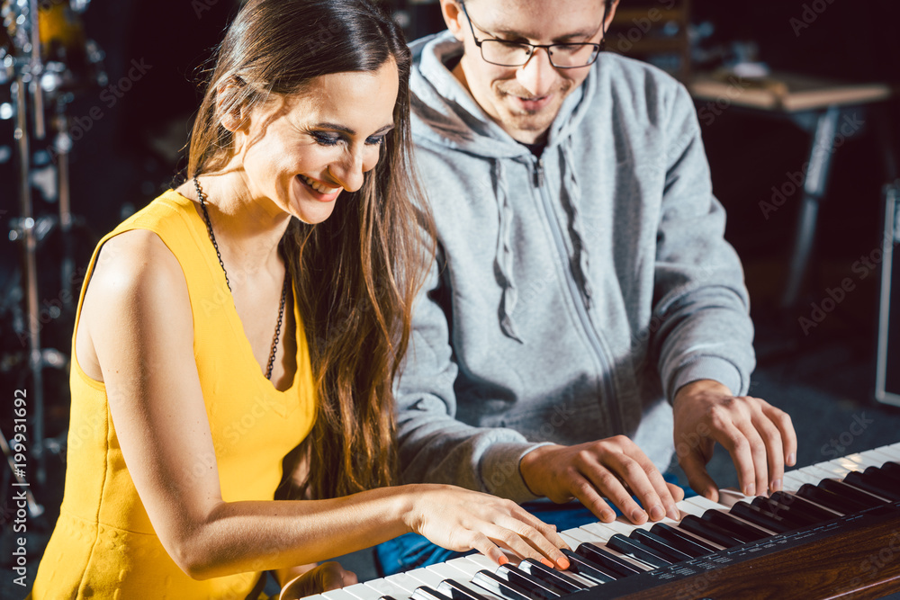 Fototapeta premium Piano teacher giving lessons to his student in music school 