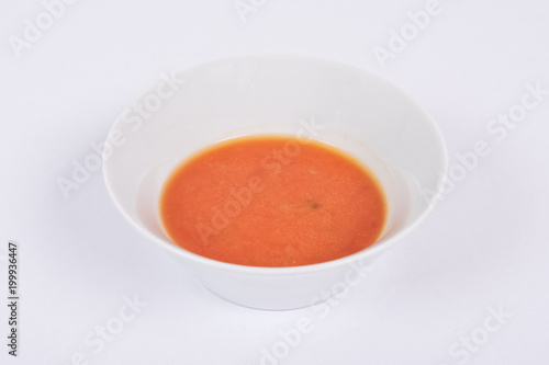 Tomato soup with milk on a white