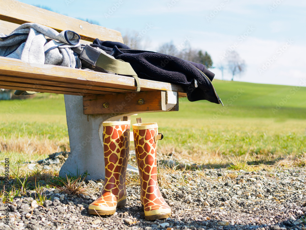 Getigerte Gummistiefel neben einer Parkbank in der Natur. Landschaft,  Wandern. Stock-Foto | Adobe Stock