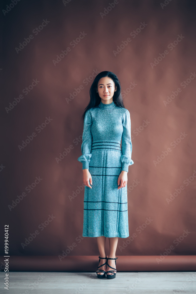 Fototapeta premium Full length portrait of beautiful asian girl in blue dress