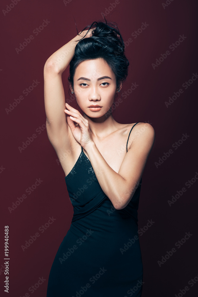 Fototapeta premium Beautiful asian woman in black dress posing in studio