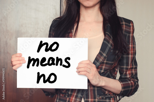 Girl holds a paper sheet with text no means no