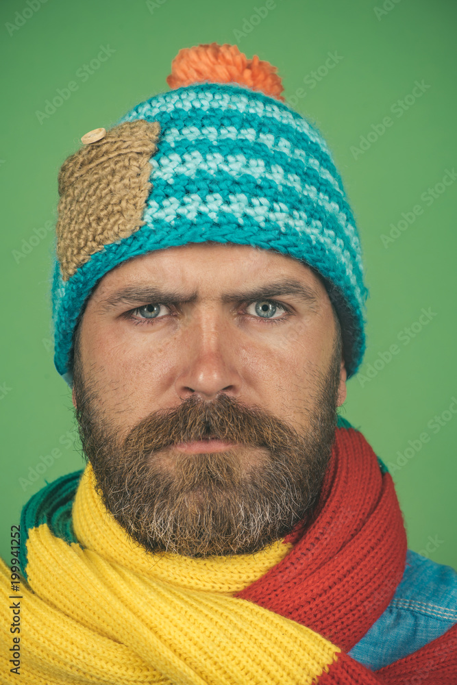 Health, beauty and people concept - portrait of serious caucasian man with beard in fashionable scarf and hat. Male winter fashion. Closeup portrait attractive bearded man in warm knitted hat, scarf. Health, beauty and people concept - portrait of serious caucasian man with beard in fashionable scarf and hat. Male winter fashion. Closeup portrait attractive bearded man in warm knitted hat, scarf.