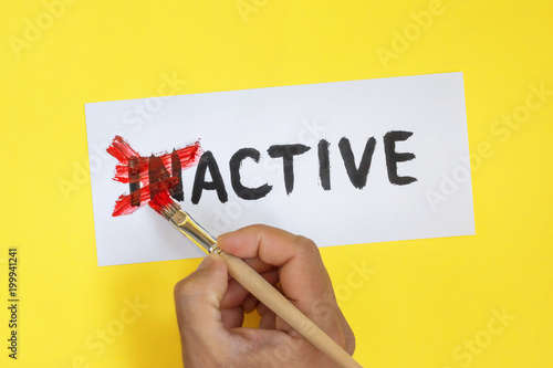 inactive is active concept. Hand with brush and card with word inactive photo