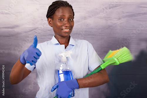 Photos smiling young housekeeper with thumb gesture