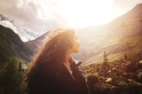 Junge Frau mit lockigem Haar genießt die Ruhe während des Sonnenuntergangs in den Dolomiten