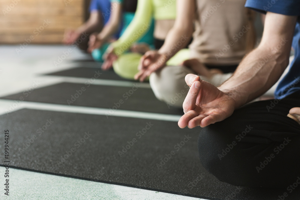 Fototapeta premium Young women and men in yoga class, relax meditation pose