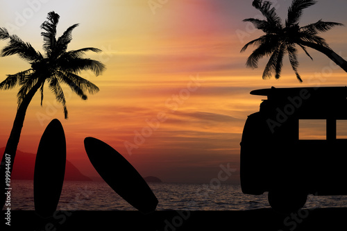 silhouette vintage car in the beach with a surfboard on the roof.Silhouette man and surfboard on sunset beach.