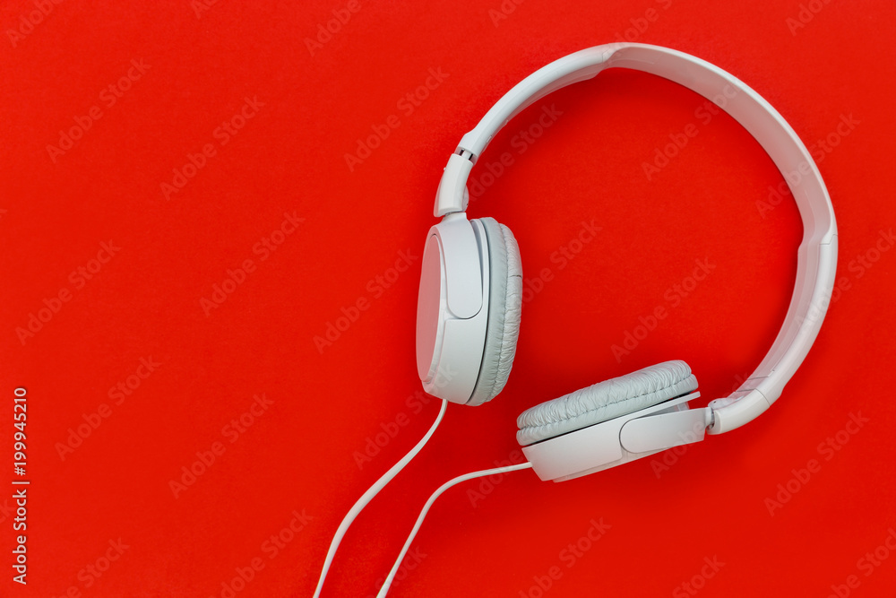 White music headphones isolated on red background White music headphones isolated on red background