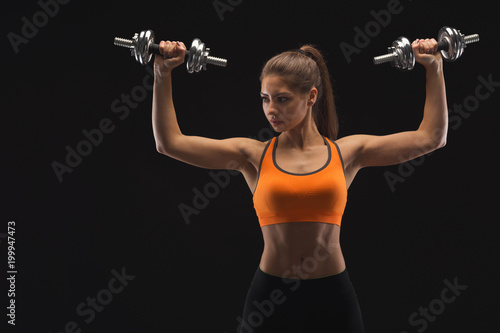 Athletic woman with dumbbells