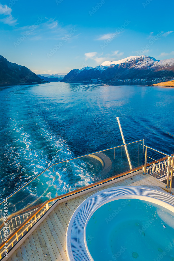 Obraz premium Above outdoor view of Hurtigruten voyage in cruise along Norwegian coast with a luxury swimming pool with a gorgeous nature background