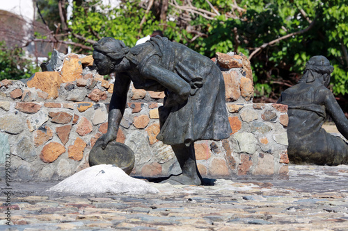 stutue of woman scouping up salt, Salt Pickers Monument, Great Salt Pond, Philipsburg, St. Martin, Lesser Antilles, Caribbean photo
