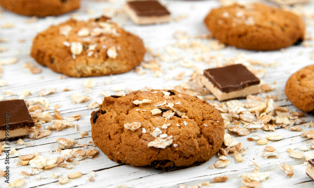 Homemade cookies and chocolate pieces on a white vintage table. Homemade cookies and chocolate pieces on a white vintage table.