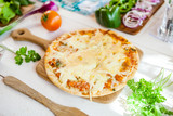 closeup fresh homemade traditional cheese italian pizza on wooden table with ingredients around. wallpaper for pizzeria and cooking food concept