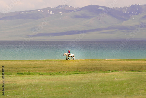 Single horse rider riding by the song Kol lake