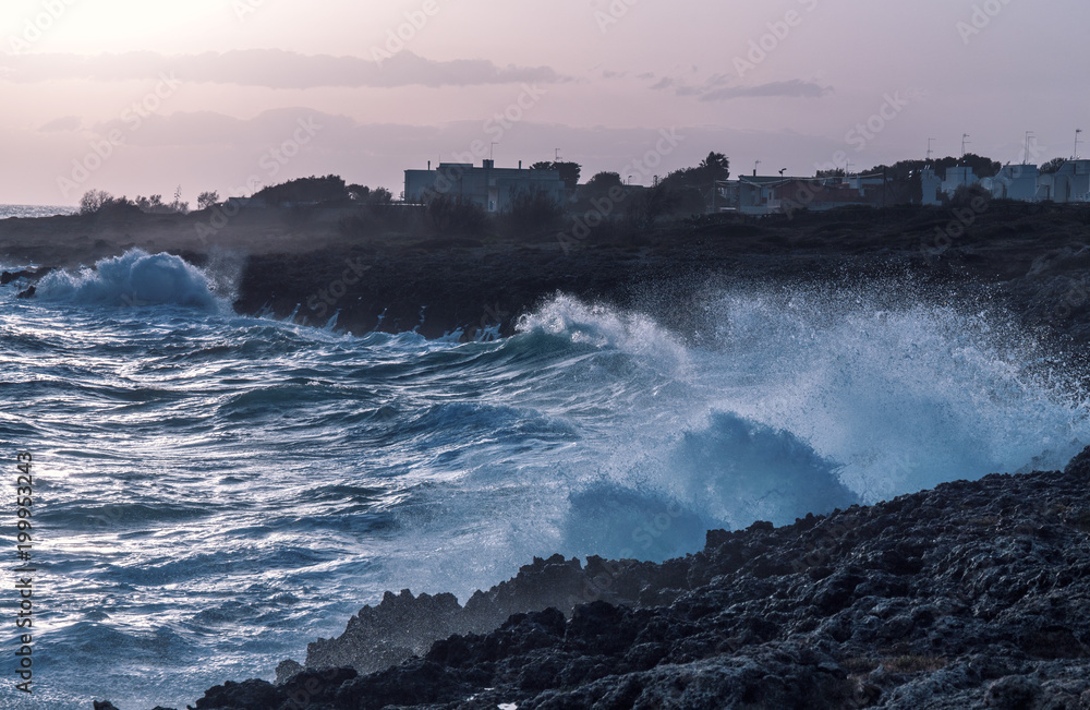 storm seascape at dusk. sunset sea over cliff and rocks. Taranto coastline