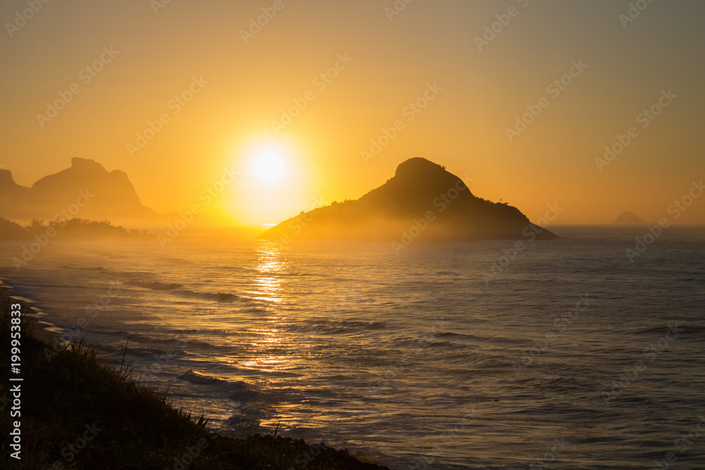 color photography of sunrise between mountain on macumba beach in rio de janeiro city