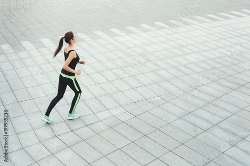 Young woman jogging in city copy space