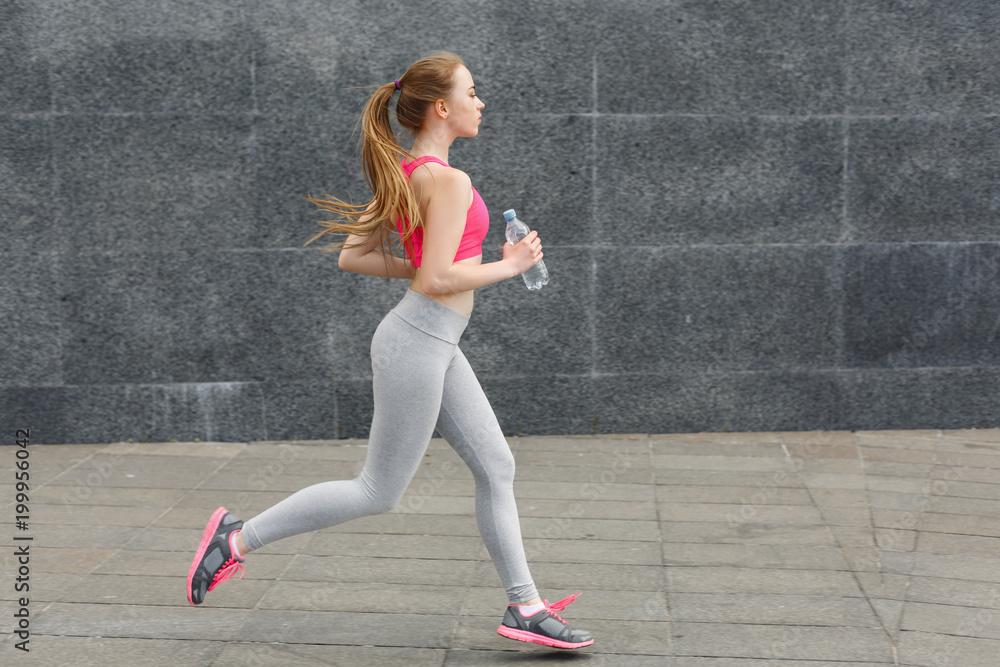 Young woman running in city copy space Young woman running in city copy space