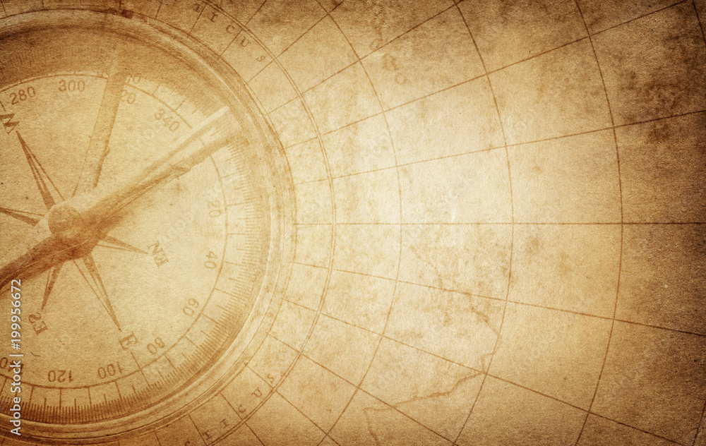 Old vintage retro compass on ancient map. Survival, exploration and nautical theme grunge background