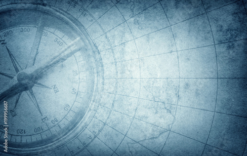 Old vintage retro compass on ancient map. Survival, exploration and nautical theme grunge blue background photo