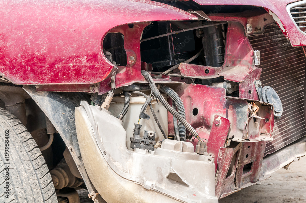 Front side of broken and damaged car wreck in crash accident with fatal outcome in collision close up Front side of broken and damaged car wreck in crash accident with fatal outcome in collision close up
