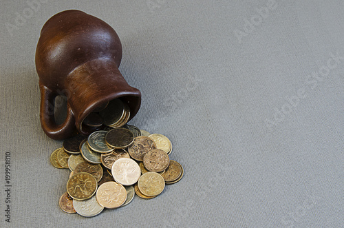 Ancient jug with coins. Old coins in a pot. photo