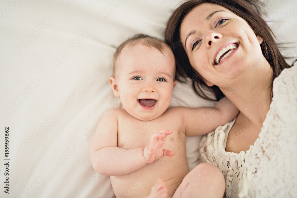 mother playing with her baby in the bedroom mother playing with her baby in the bedroom