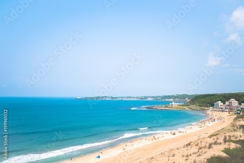 "Aerial view of sandy beach with tourists swimming in beautiful clear sea water"