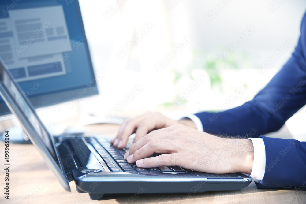 Close-up shot of businessman's hands while typing on keyboard. Professional man wearing suit while sitting at office desk and workin on laptop. Close-up shot of businessman's hands while typing on keyboard. Professional man wearing suit while sitting at office desk and workin on laptop.