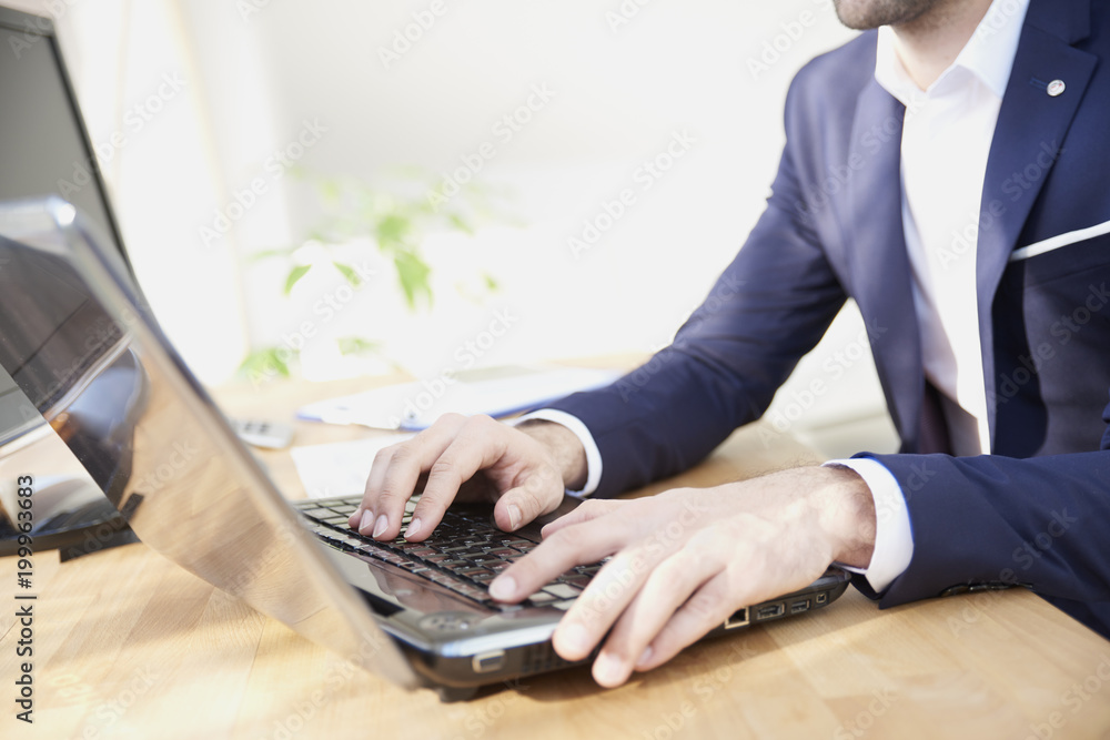 Close-up shot of businessman's hands while typing on keyboard. Professional man wearing suit while sitting at office desk and workin on laptop. Close-up shot of businessman's hands while typing on keyboard. Professional man wearing suit while sitting at office desk and workin on laptop.