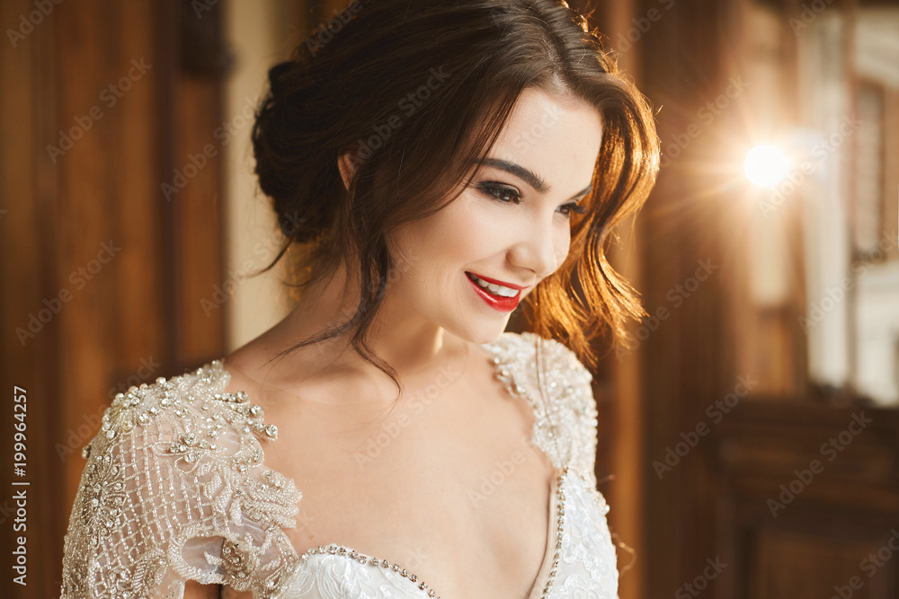 Fashionable photo of beautiful smiling young brunette woman in lace dress. Happy bride, wedding preparation