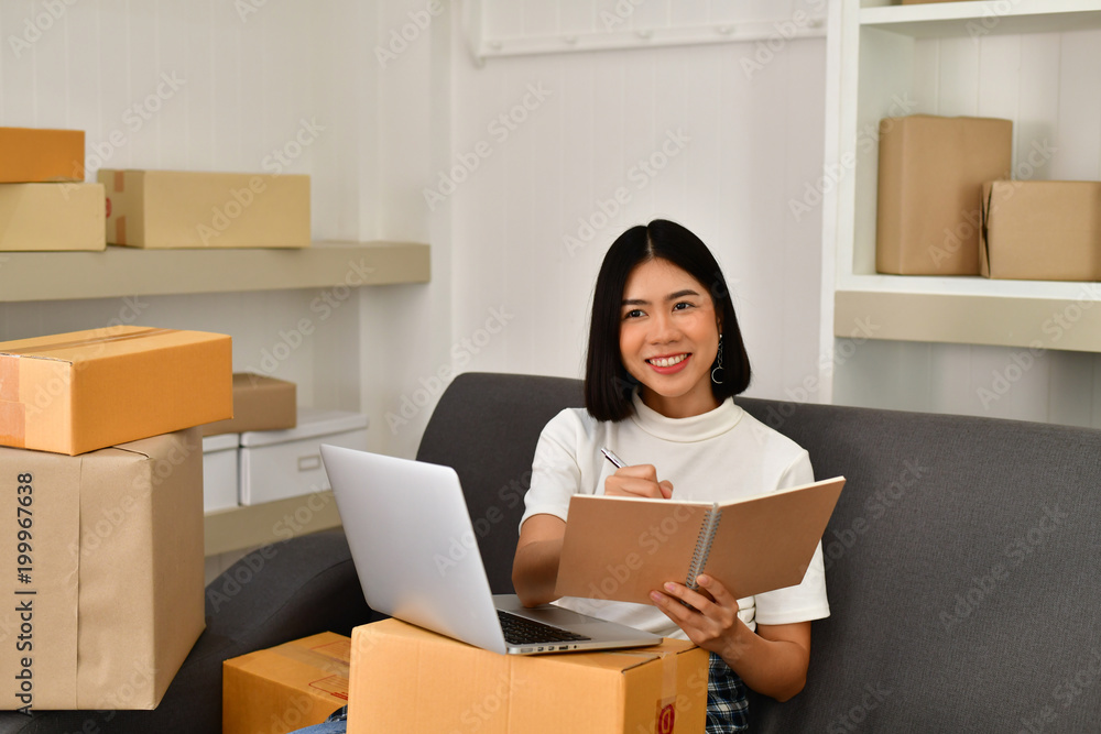 Sme business concept. Young Asian people are packing their packages.Delivery business  Small and Medium Enterprise (SMEs). Young man is working in the house.Young Owner Start up for Business Online.