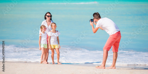 Panorama of family of four taking a selfie photo on their beach holidays. Family beach vacation