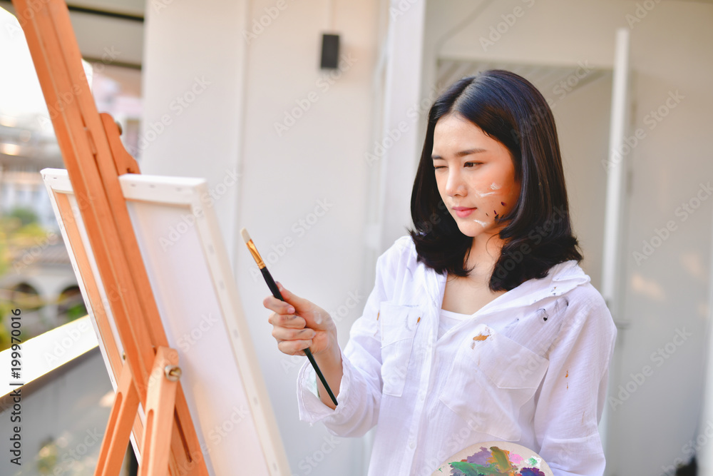 Concept Artist Beautiful girl. Beautiful women are creating art. Beautiful woman is painting happily. Young artist painting outside the house. Concept Artist Beautiful girl. Beautiful women are creating art. Beautiful woman is painting happily. Young artist painting outside the house.