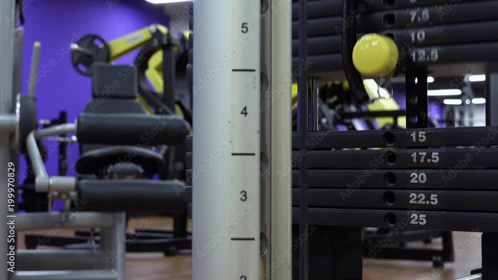 Weight load moves up and down as someone trains on a machine in a gym - closeup Weight load moves up and down as someone trains on a machine in a gym - closeup