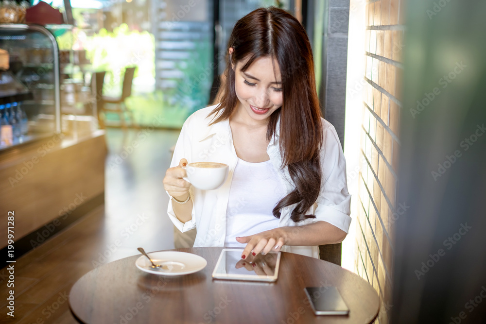 Young and beautiful Asian freelance business woman using a smart phone at the restaurant terrace in the urban city Young and beautiful Asian freelance business woman using a smart phone at the restaurant terrace in the urban city