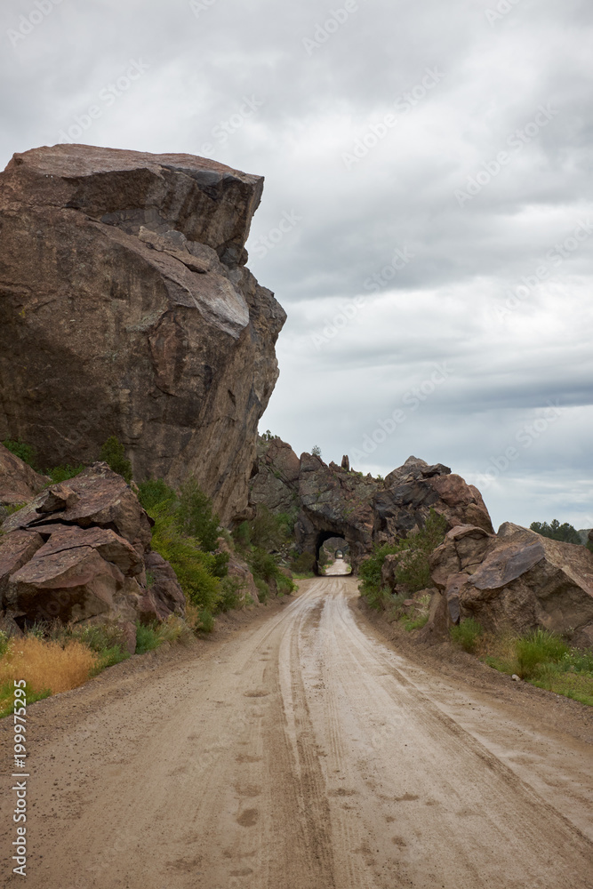 Dirt road along rocks toward tunnel