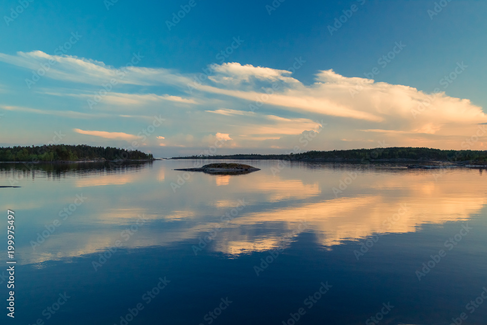 Reflection of clouds in the water. Islands on the horizon. Wild nature. Calm on the lake. Karelia Ladoga Lake.