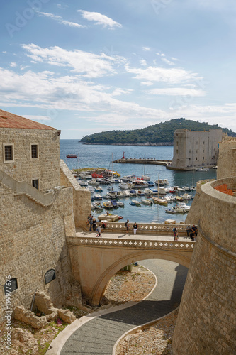 Port and tourists viewed through fortress walls in Dubrovnik, Croaria photo