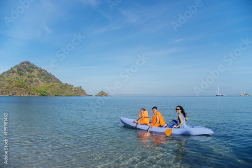 Mother and children kayaking on the beach © Creativa Images