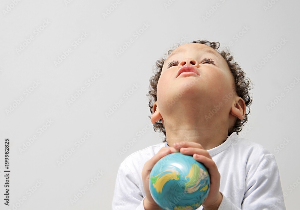 Naklejka premium boy holding globe on earth day