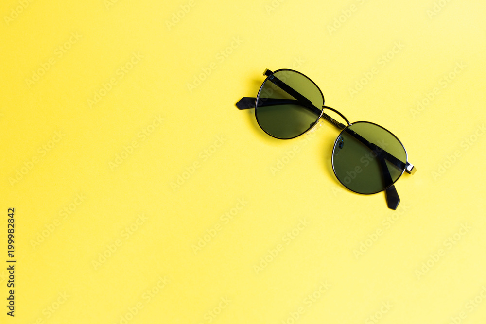 sunglasses on a yellow isolated background close-up On the right in a corner sunglasses on a yellow isolated background close-up On the right in a corner