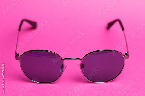 Summer sunglasses on pink isolated background close-up