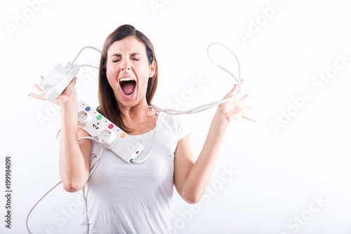 A beautiful young woman screaming with power cables in her hands