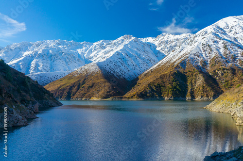 Beautiful view of the snowy peaks, blue sky and mountain lake