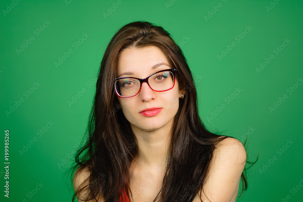 Studio Portrait of Cute Smart Girl in Eyeglasses and Red Top on Green Background. Studio Portrait of Cute Smart Girl in Eyeglasses and Red Top on Green Background.
