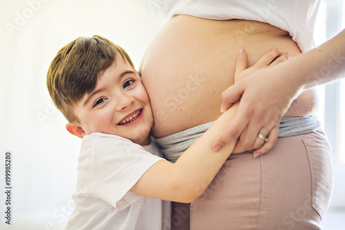 pregnant woman with her son on bedroom together